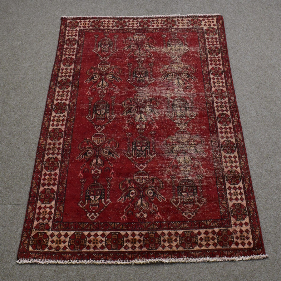 Full length view of Shiraz rug 118x188 cm showing worn red background and subtle geometric medallions