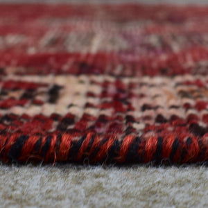Low angle close-up of Shiraz rug pile showing short wool texture and visible wear