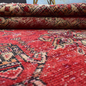 Macro detail of distressed red field with softened pattern definition and color variation