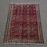 Hand knotted Shiraz Persian rug with repeating geometric tribal motifs on deep red field and narrow patterned borders