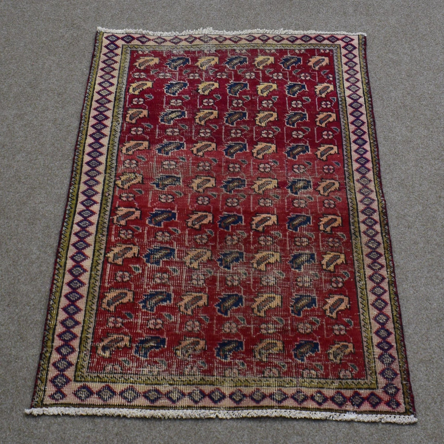 Hand knotted Shiraz Persian rug with repeating geometric tribal motifs on deep red field and narrow patterned borders