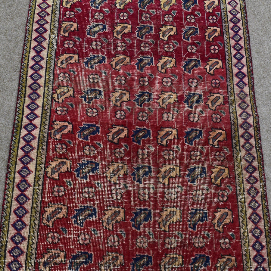 Close view of vintage Shiraz Persian rug showing dense rows of traditional tribal motifs in red, ivory and blue tones