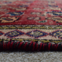 Macro close up of Persian Shiraz rug border showing colorful geometric guard stripes and wool pile texture