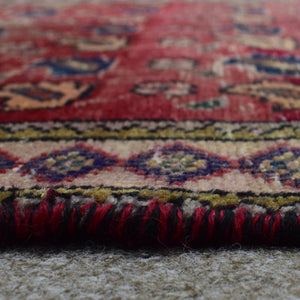 Macro close up of Persian Shiraz rug border showing colorful geometric guard stripes and wool pile texture