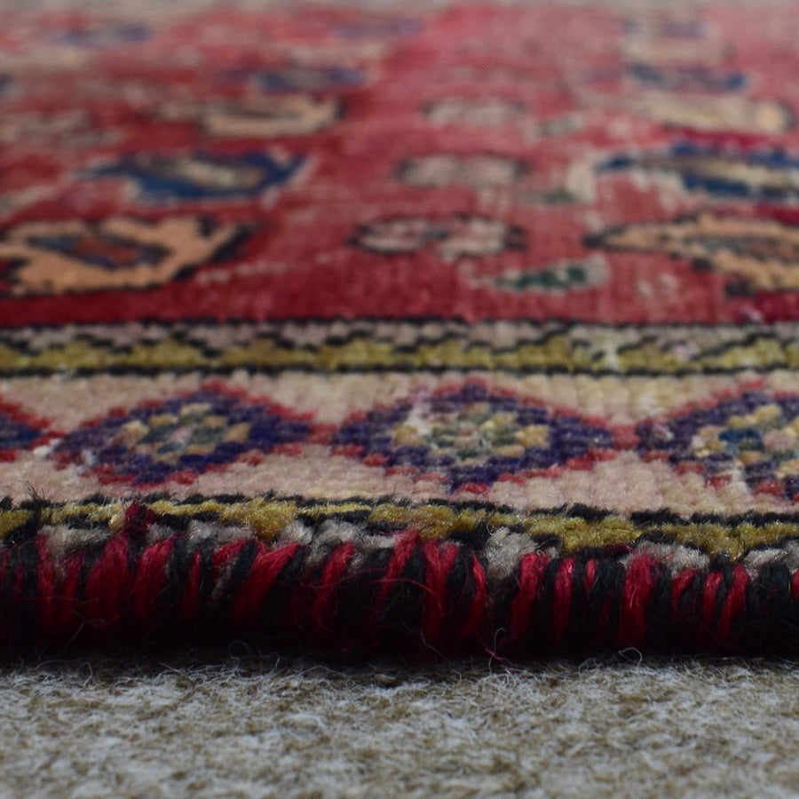 Macro close up of Persian Shiraz rug border showing colorful geometric guard stripes and wool pile texture
