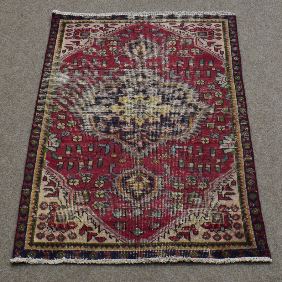 Vintage Persian Shiraz rug 90x137 cm showing central ivory medallion and geometric tribal motifs on deep red background