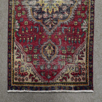Section of Shiraz Persian rug showing central medallion edge and repeating tribal motifs on red field
