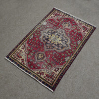 Hand knotted Shiraz Persian rug photographed at an angle featuring large central medallion and traditional tribal border