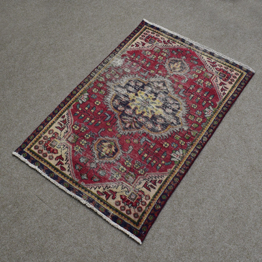 Hand knotted Shiraz Persian rug photographed at an angle featuring large central medallion and traditional tribal border