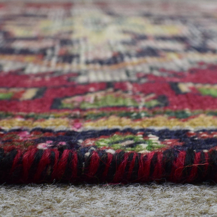 Macro close up of Persian Shiraz rug border showing colorful geometric guard stripes and wool texture