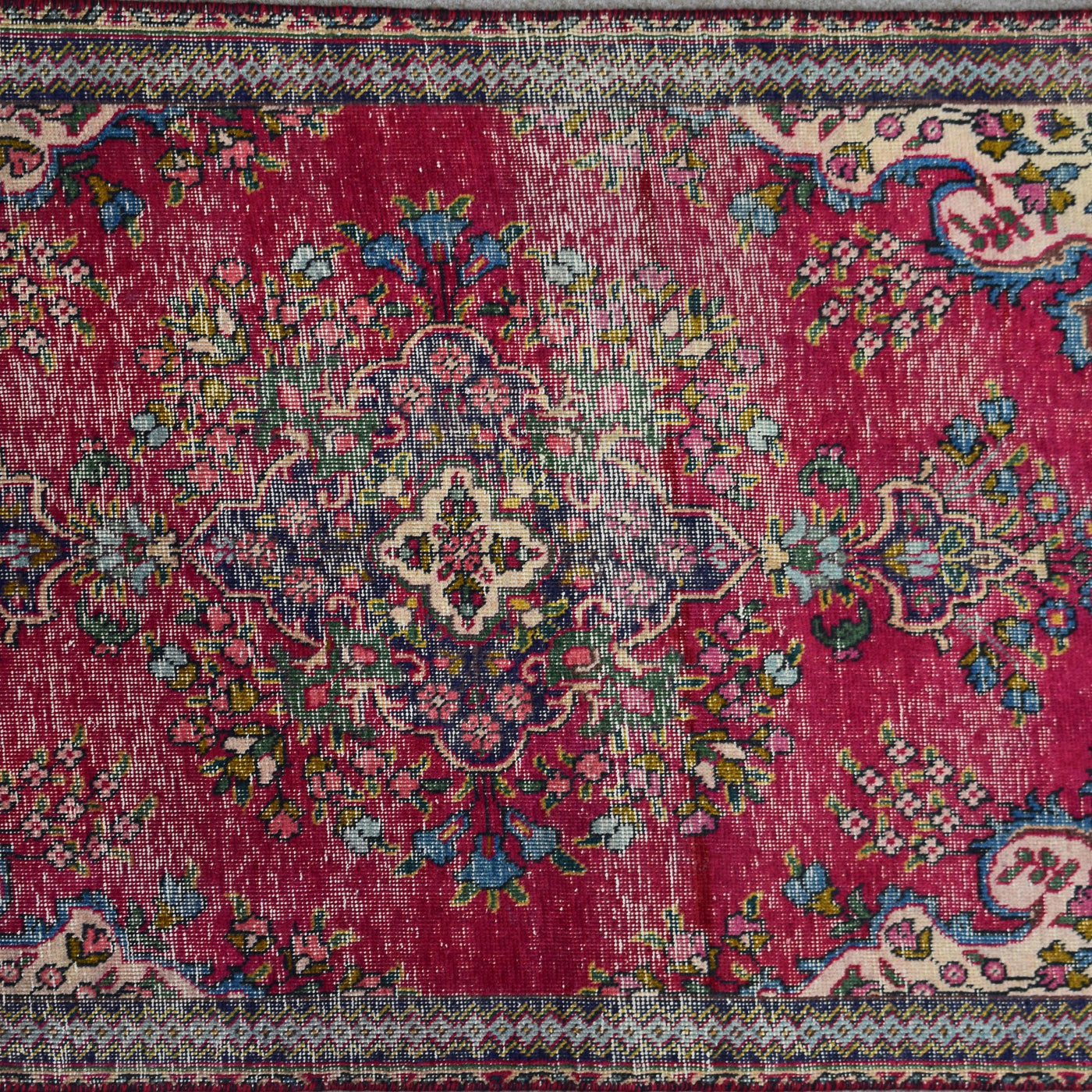 Close up of Persian Shiraz rug medallion showing intricate floral design in ivory, blue and red tones