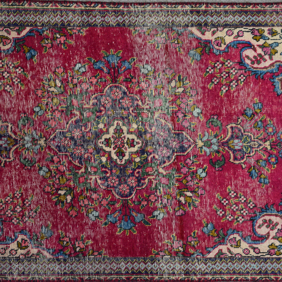 Close up of Persian Shiraz rug medallion showing intricate floral design in ivory, blue and red tones
