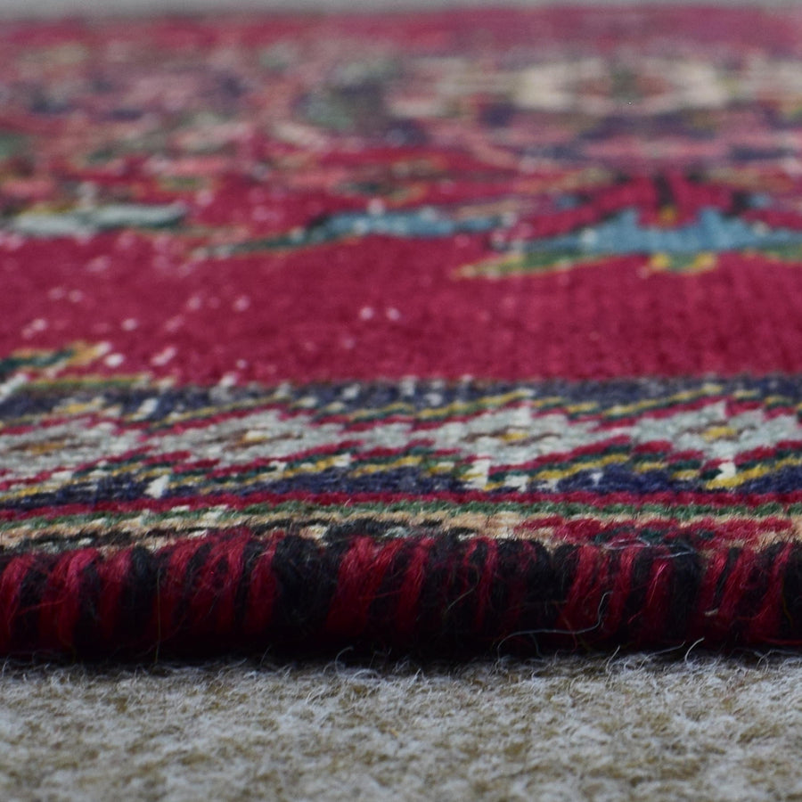 Macro close up of vintage Persian Shiraz rug pile showing wool texture and colorful woven pattern