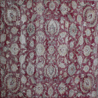 Close up of distressed Persian rug showing worn red background with repeating floral medallion motifs