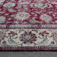 Close up of Persian rug border with ivory guard stripes and colorful floral motifs