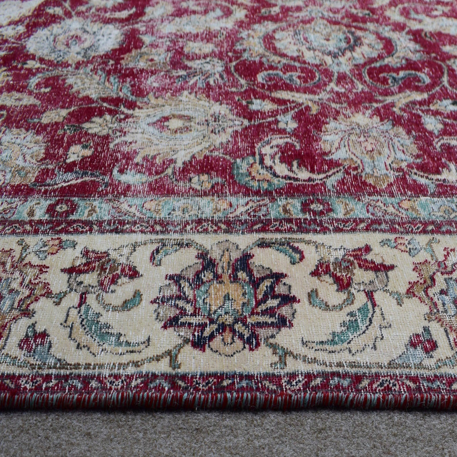 Close up of Persian rug border with ivory guard stripes and colorful floral motifs