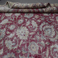Macro view of distressed Persian rug pattern showing worn floral elements and soft wool texture