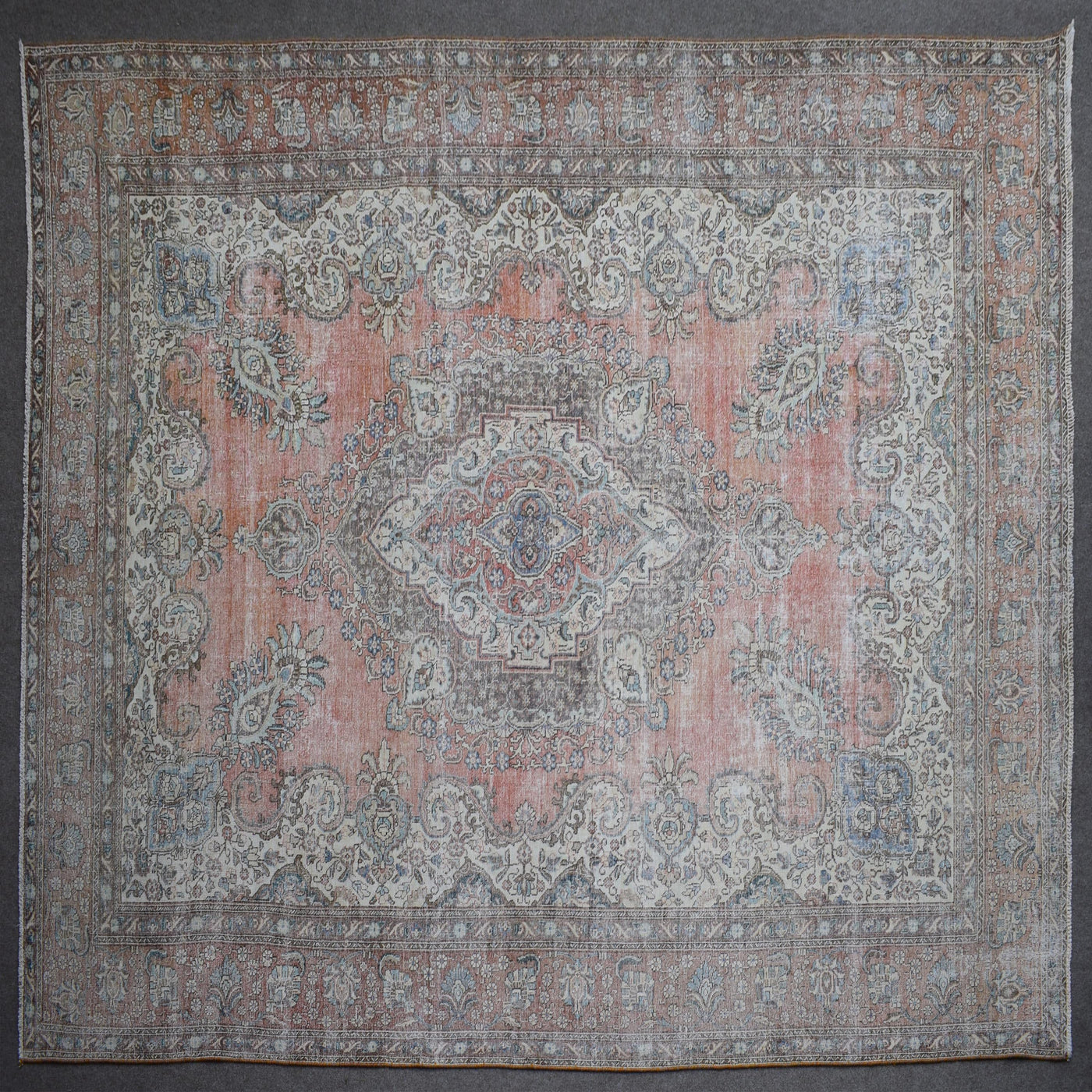 Close up of Persian rug border with traditional floral motifs in soft blue and ivory tones