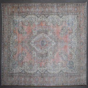 Close up of Persian rug border with traditional floral motifs in soft blue and ivory tones
