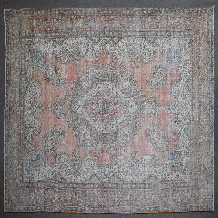 Close up of Persian rug border with traditional floral motifs in soft blue and ivory tones