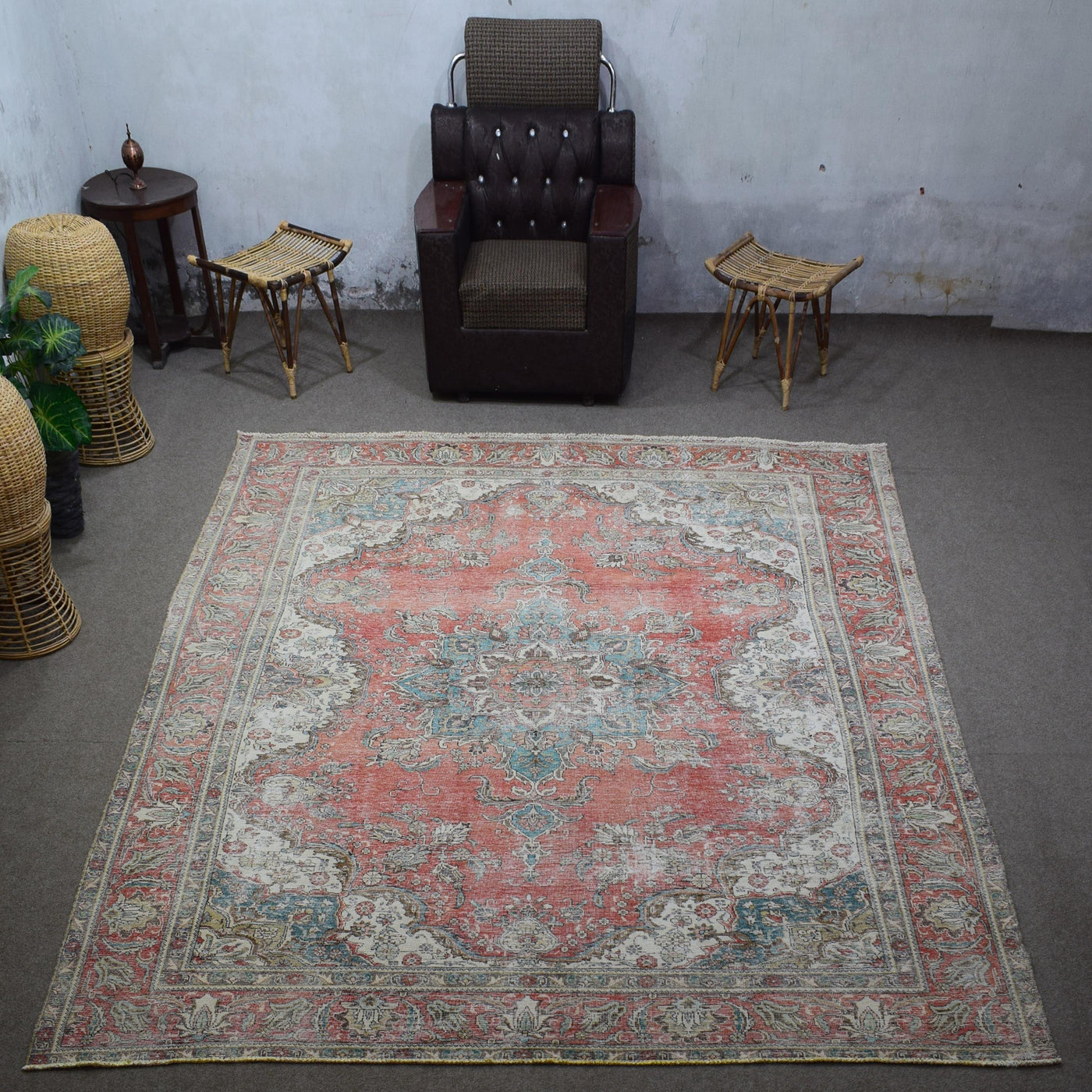 Large distressed vintage Persian rug 292x385 cm styled in interior showing worn coral tones and decorative medallion