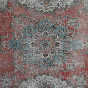 Detailed view of vintage Persian rug pattern featuring intricate floral medallion on coral red background