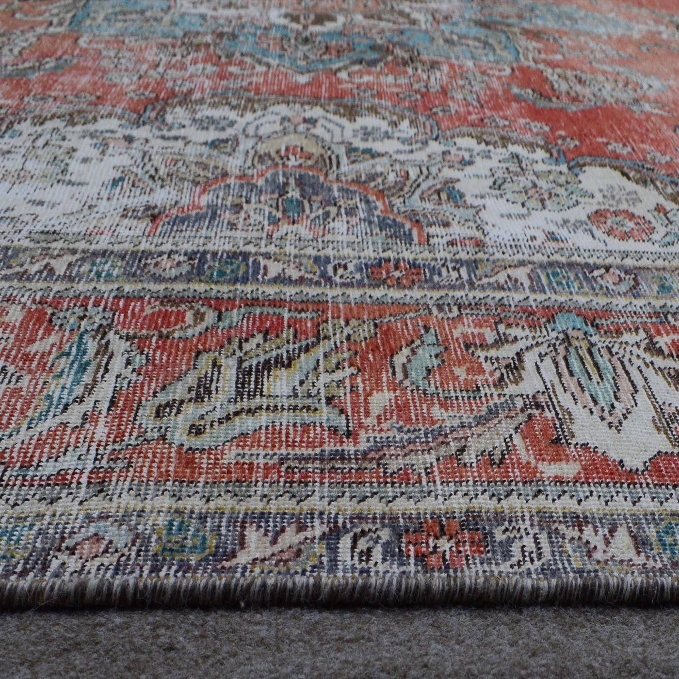 Close up of Persian rug border with decorative floral motifs and ivory guard stripes
