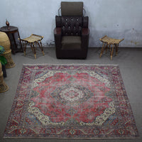 Large distressed vintage Persian rug 275x372 cm styled in interior showing worn red tones and classic medallion design