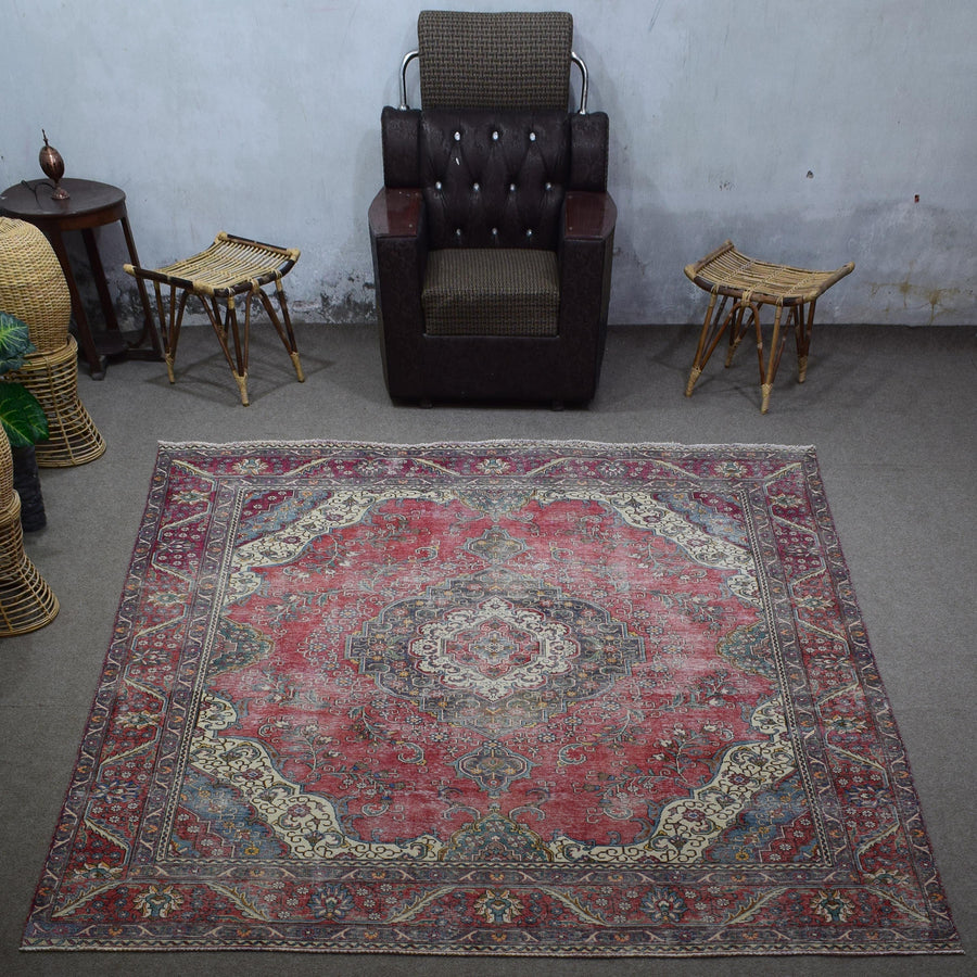 Large distressed vintage Persian rug 275x372 cm styled in interior showing worn red tones and classic medallion design