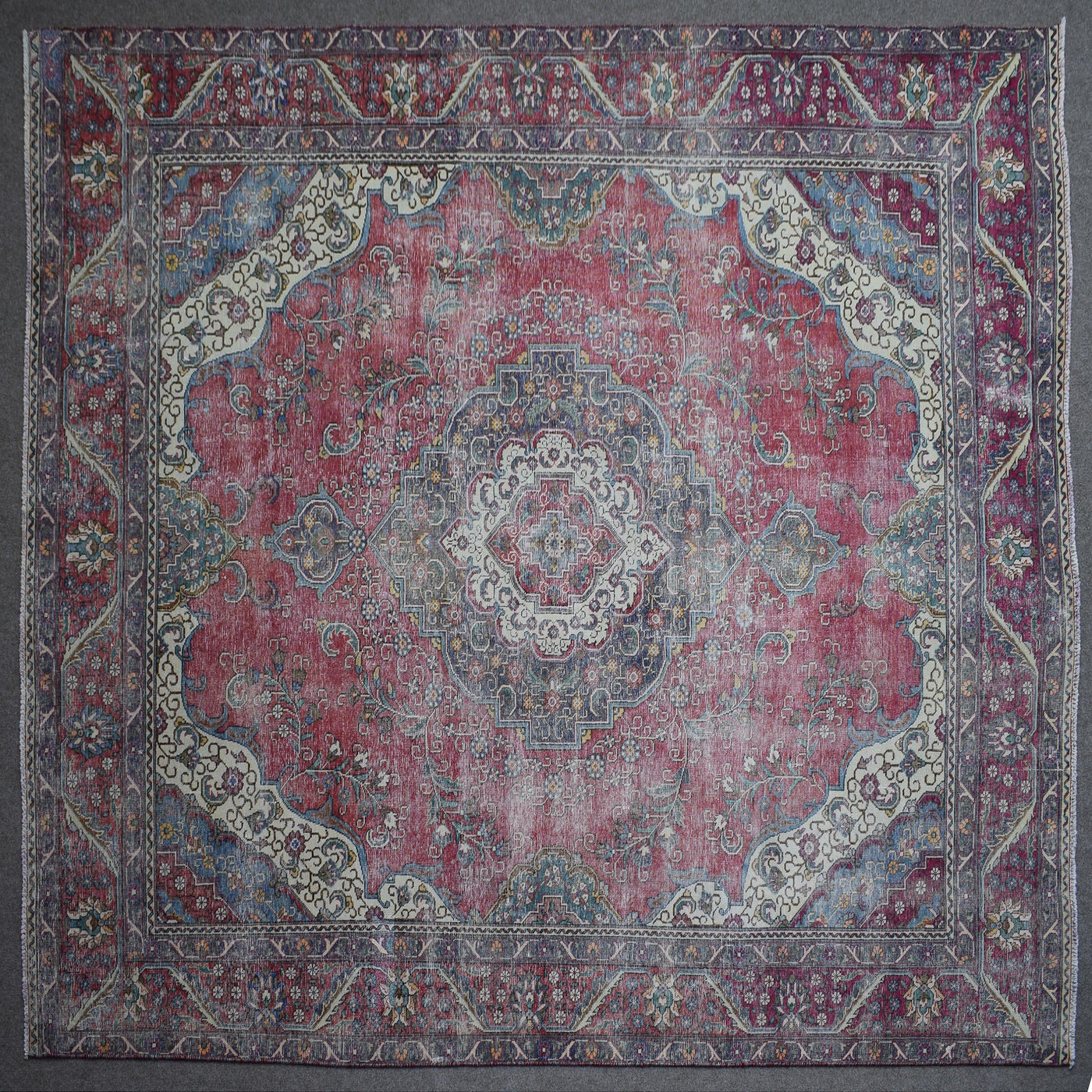 Close up of Persian rug border with colorful floral motifs and intricate guard stripes