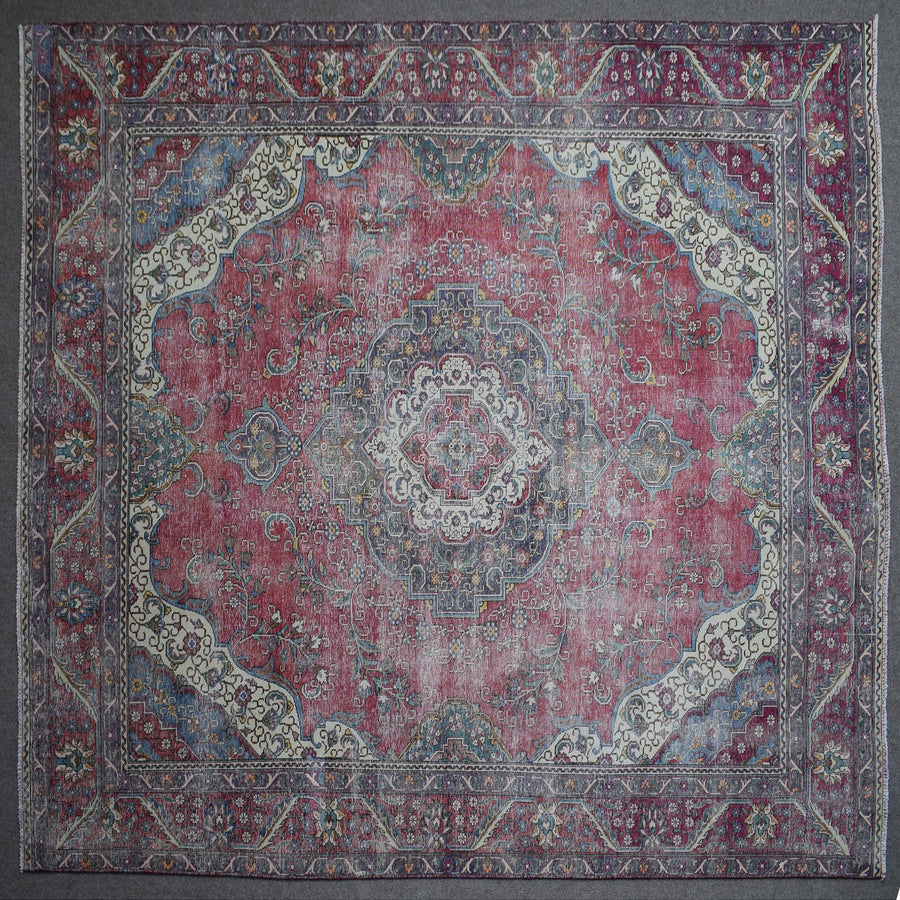 Close up of Persian rug border with colorful floral motifs and intricate guard stripes