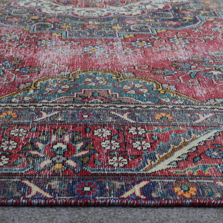 Macro close up of Persian rug medallion highlighting dense floral elements and wool texture