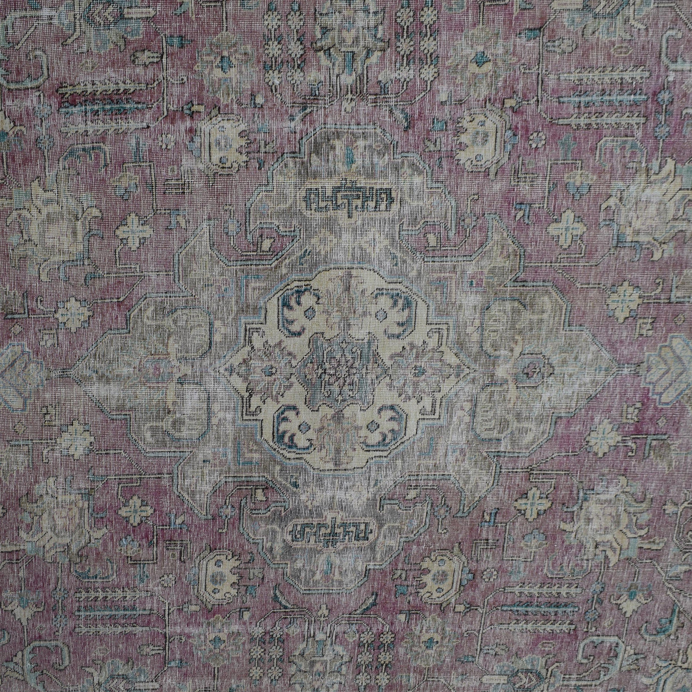 Detailed view of vintage Persian rug medallion featuring soft ivory and blue floral elements