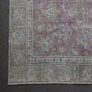 Corner detail of Persian rug with decorative floral border and aged vintage patina
