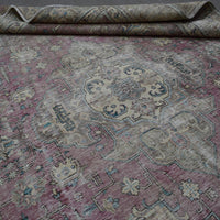Detailed view of Persian rug medallion highlighting intricate floral design and distressed surface