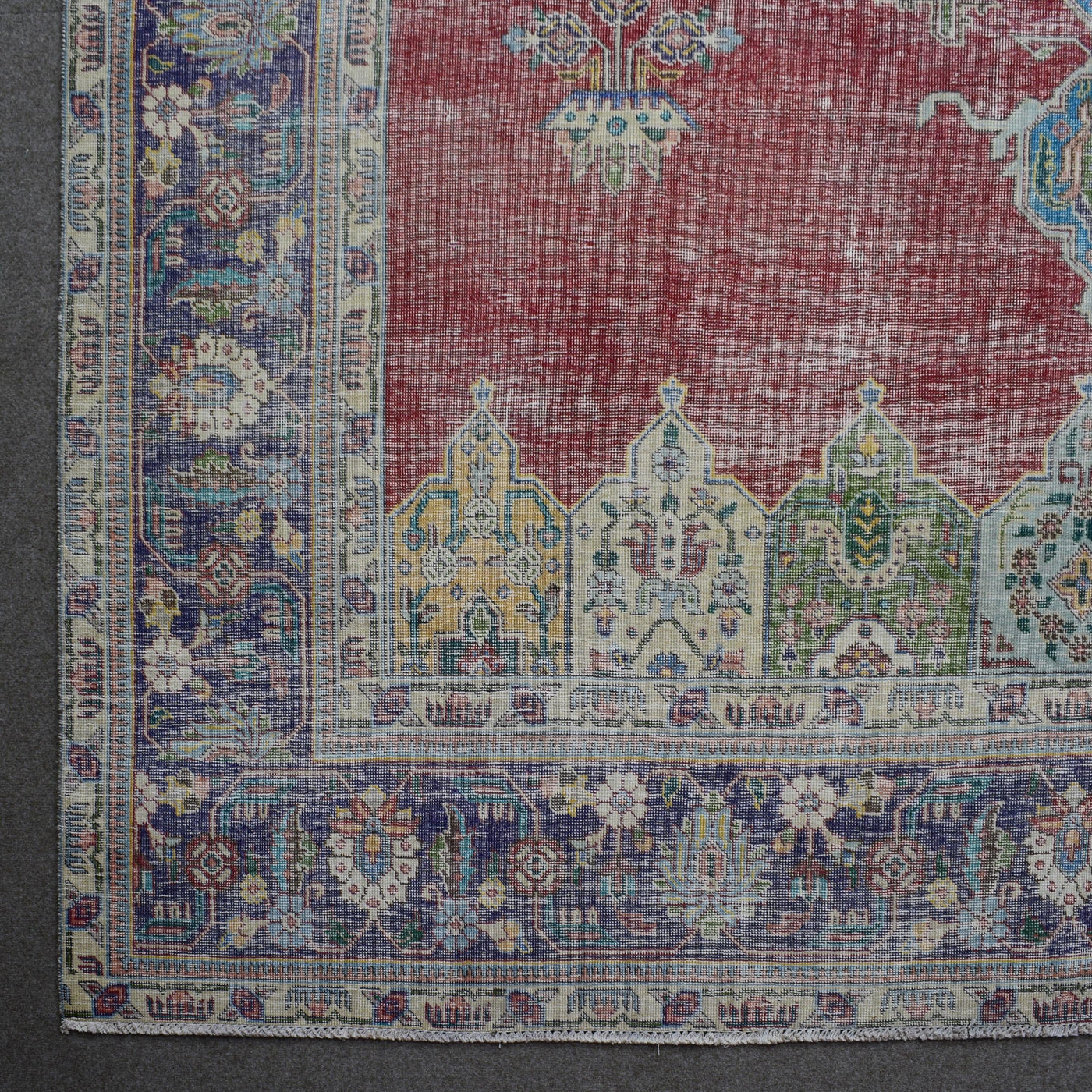 Corner detail of Persian rug with decorative border and colorful traditional motifs
