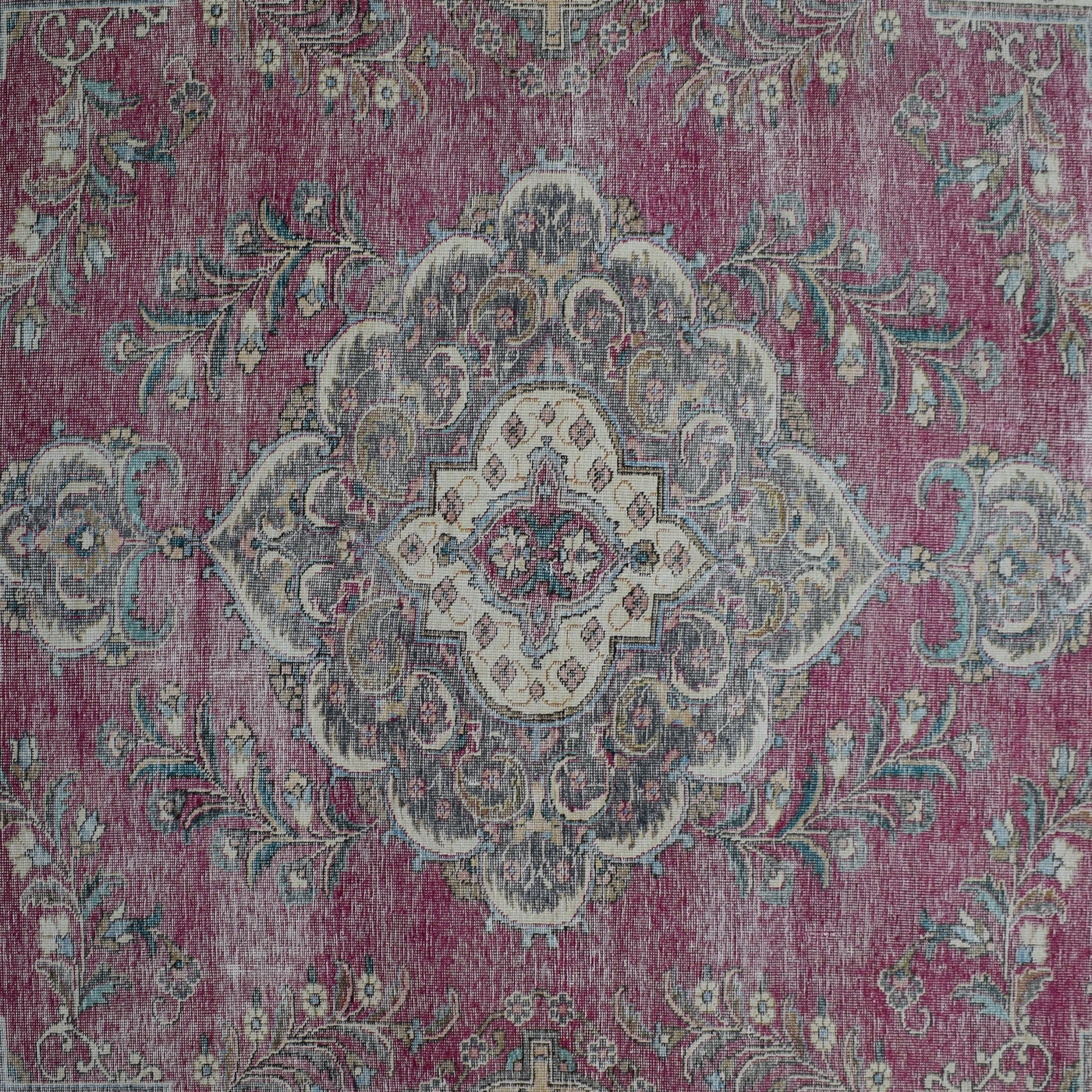 Detailed view of vintage Persian rug medallion featuring ivory and blue floral motifs