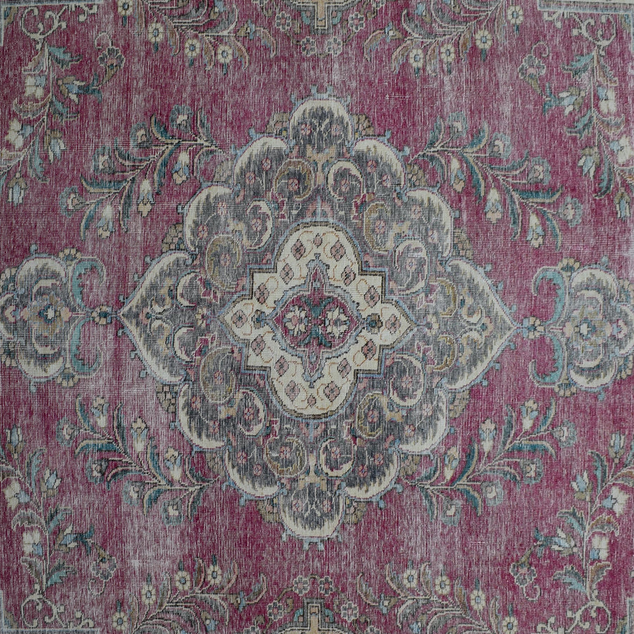 Detailed view of vintage Persian rug medallion featuring ivory and blue floral motifs
