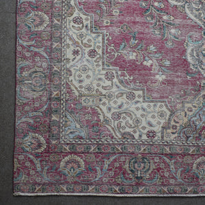 Corner detail of Persian rug with decorative floral border and aged vintage patina