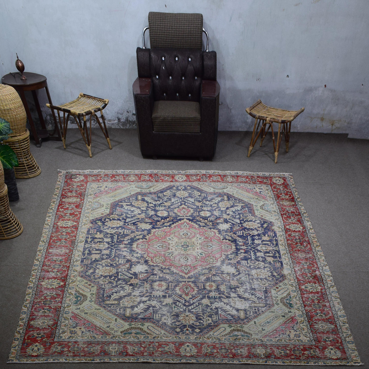 Large distressed vintage Persian rug 285x383 cm styled in interior showing navy background and decorative medallion