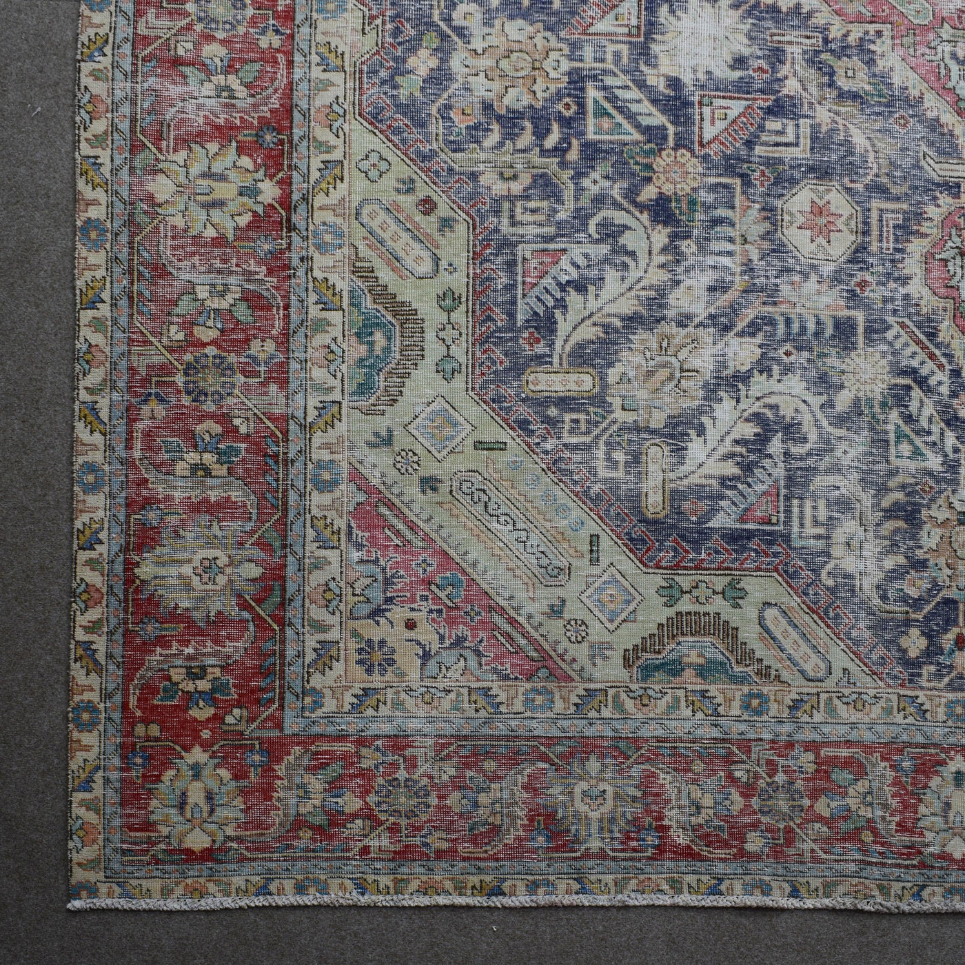 Corner detail of Persian rug with decorative border and traditional Persian motifs in navy and ivory