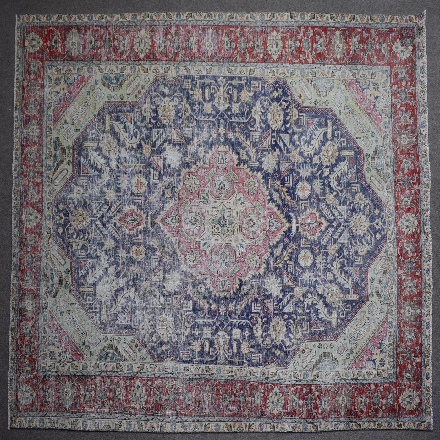 Close up of Persian rug border with colorful floral motifs and intricate guard stripes