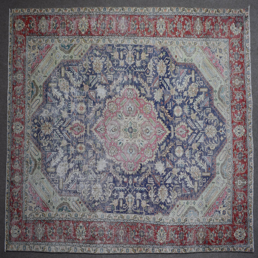 Close up of Persian rug border with colorful floral motifs and intricate guard stripes