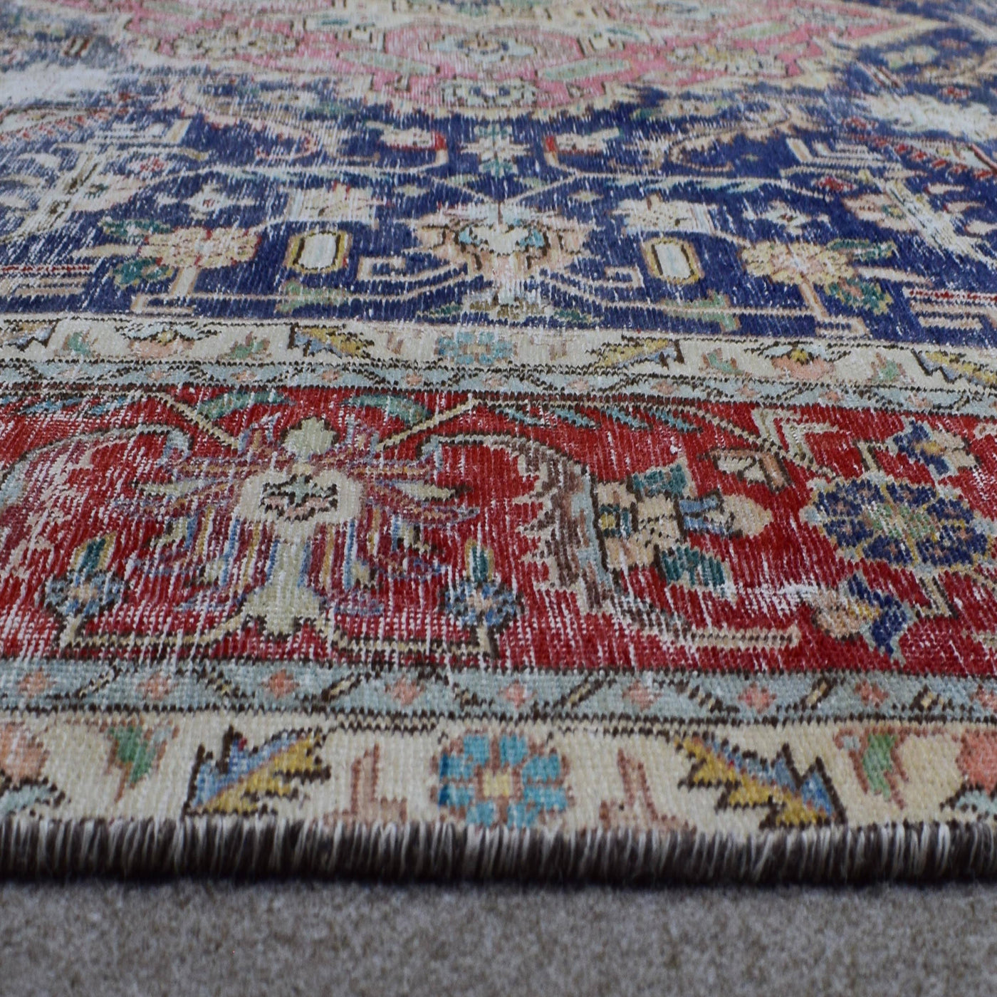 Macro detail of Persian rug medallion highlighting dense floral patterns and wool texture