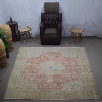 Large distressed vintage Persian rug 305x383 cm styled in interior showing soft coral tones and classic medallion design