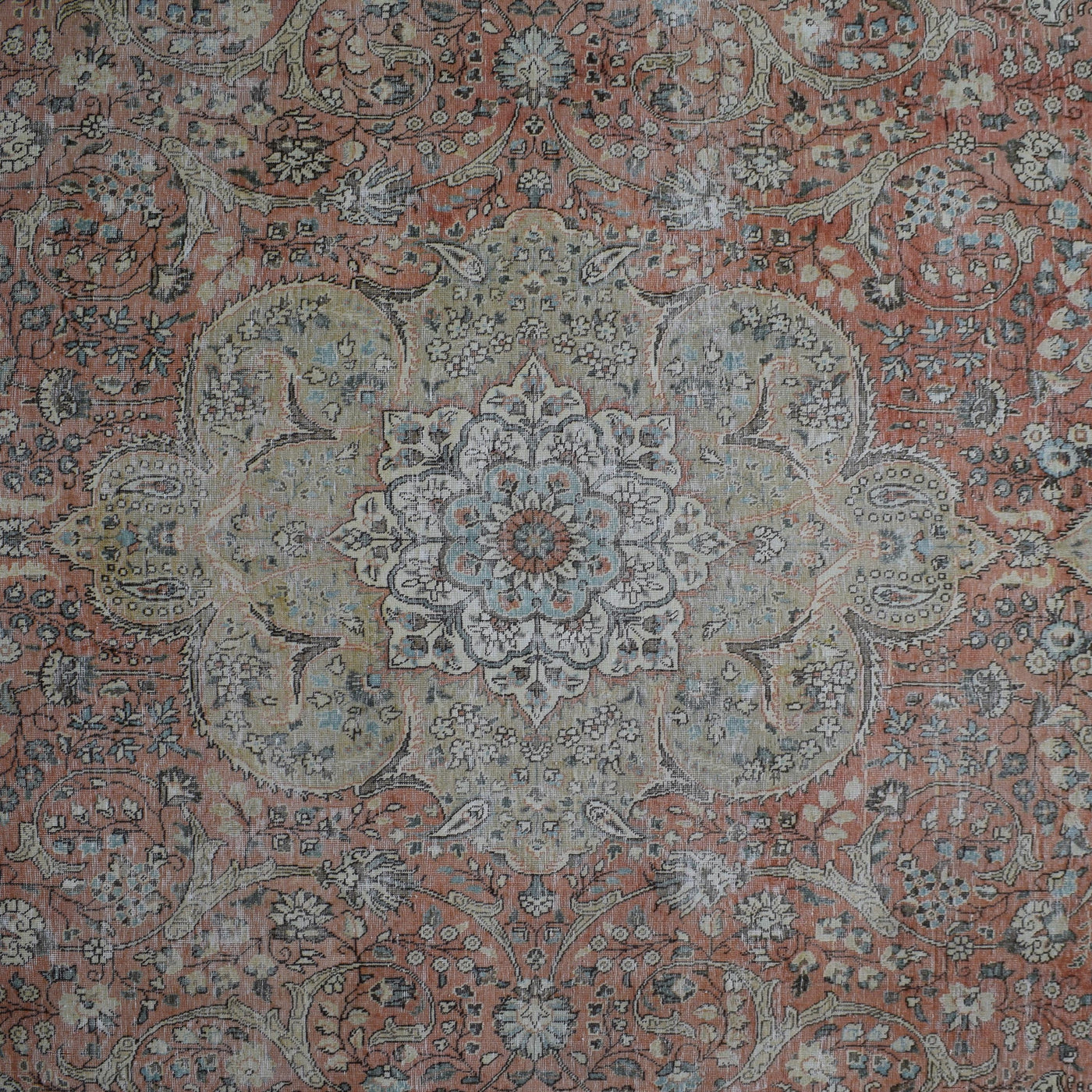 Detailed view of vintage Persian rug medallion featuring ivory and blue floral motifs