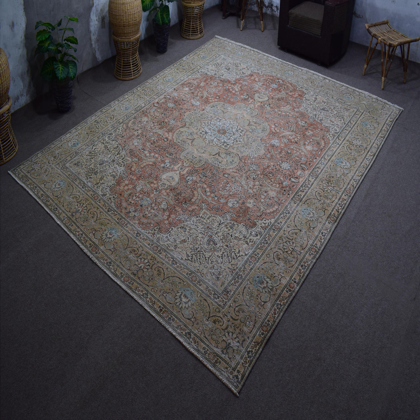 Hand knotted Persian rug photographed at an angle showing overall medallion layout and distressed vintage palette