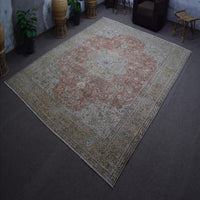 Hand knotted Persian rug photographed at an angle showing overall medallion layout and distressed vintage palette