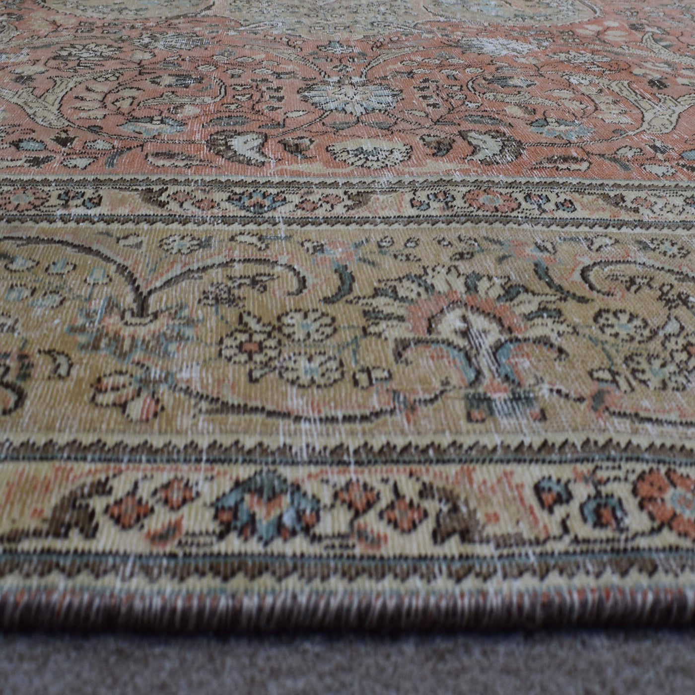 Macro detail of Persian rug medallion highlighting delicate floral elements and wool texture