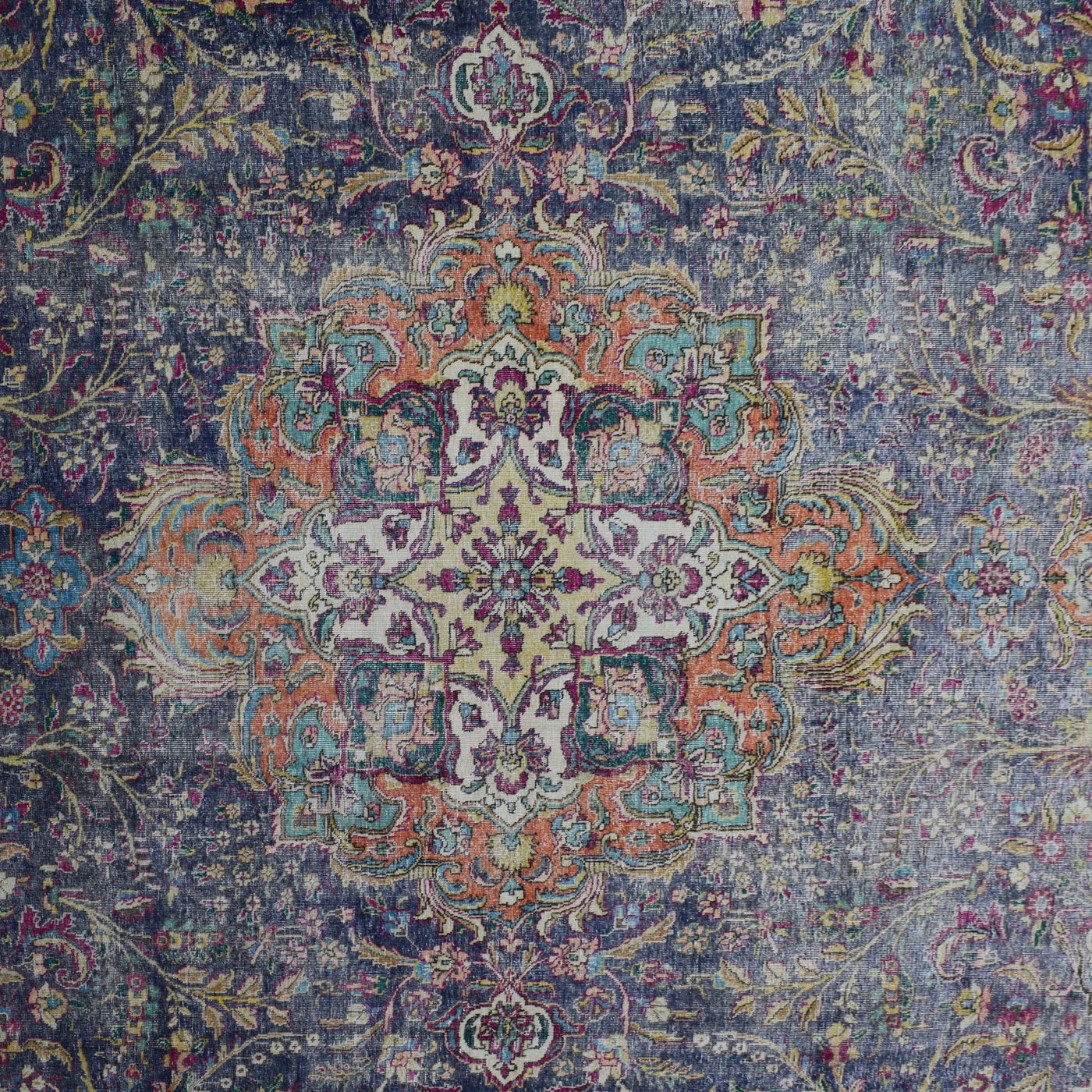 Detailed view of vintage Persian rug medallion featuring colorful floral motifs on dark navy field
